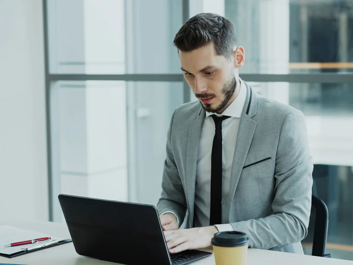A title professional working a file at a laptop in the office