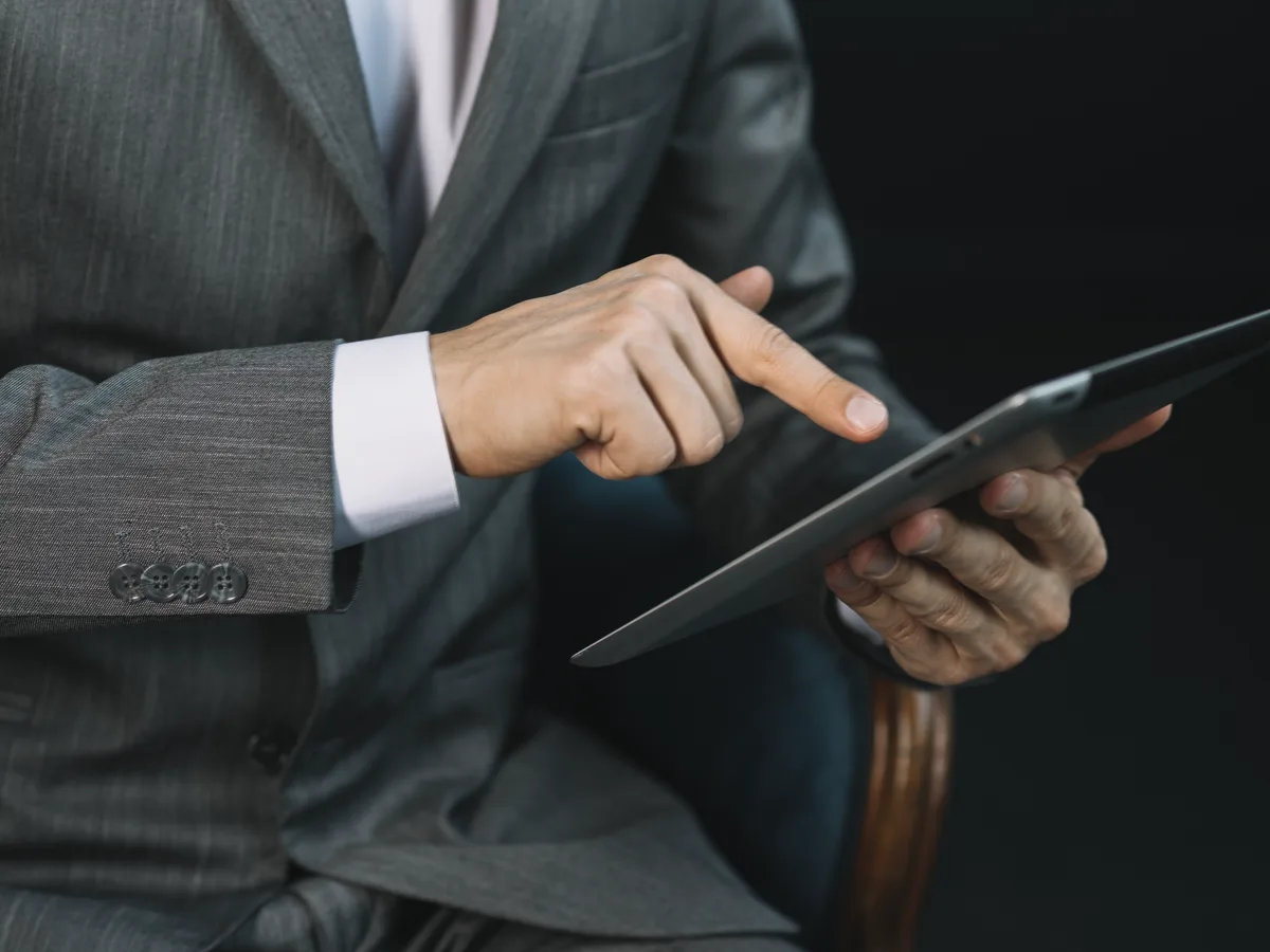 A hand opening a file on a tablet screen