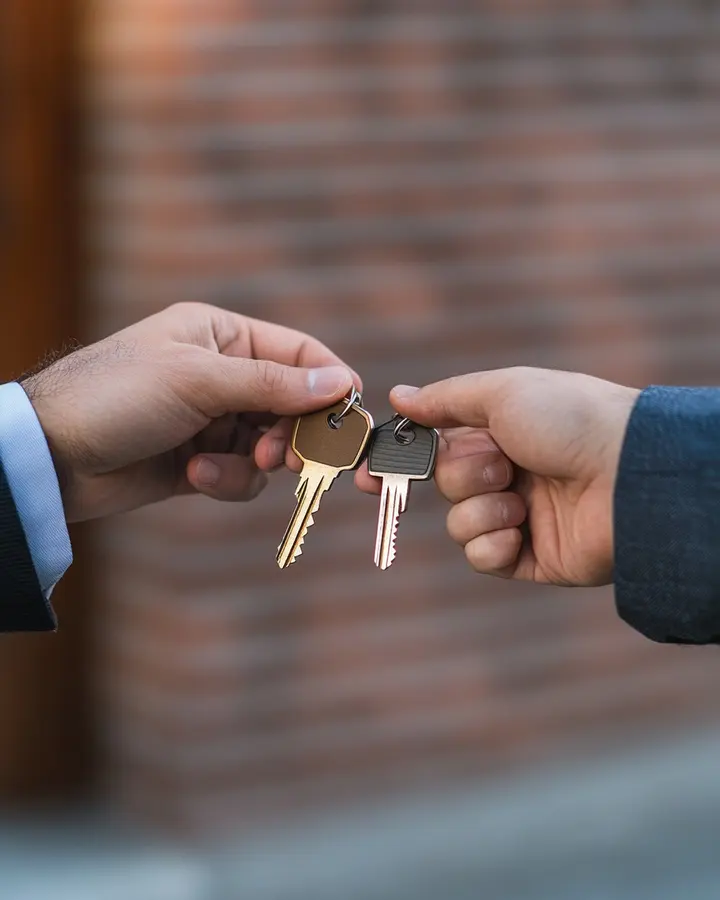 Keys passing from one hand to another outside a building